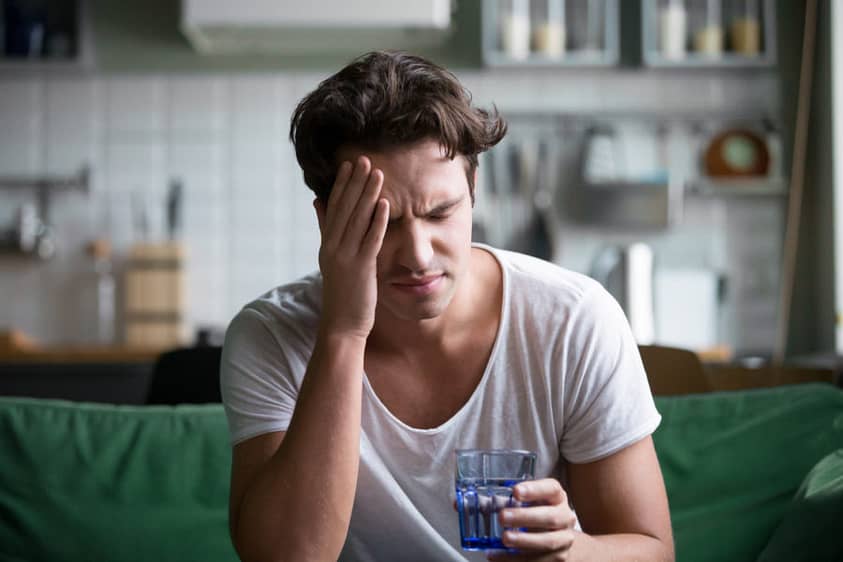 A man struggling with alcohol withdrawal symptoms at home
