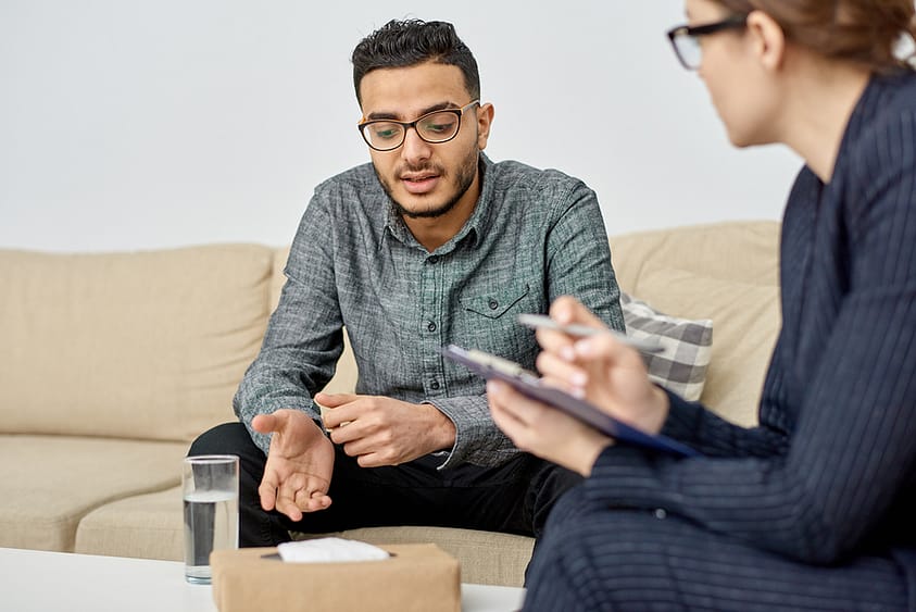 A young man engages with his therapist in one-on-one therapy.