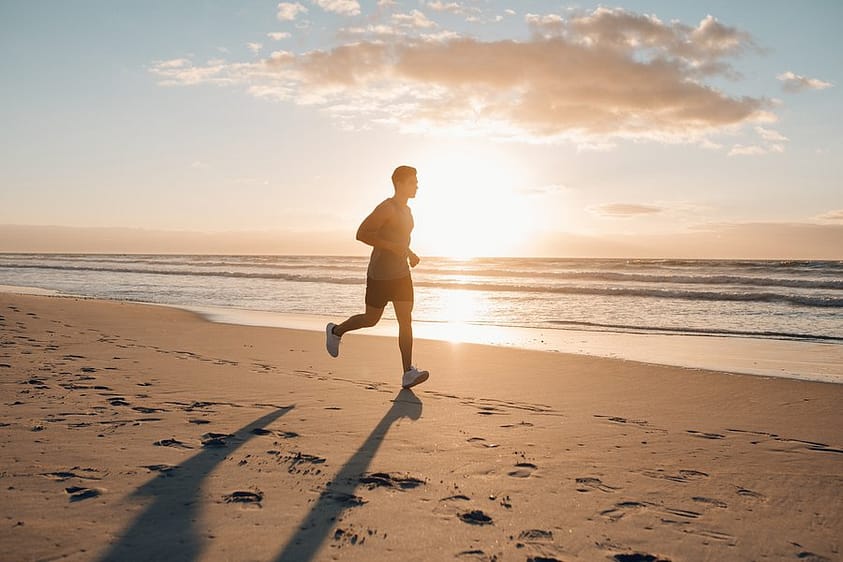 A man in recovery from substance abuse jogs on a beach in Florida.