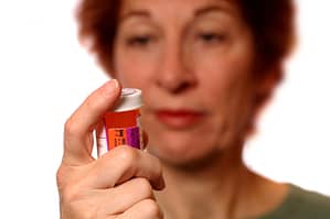 A woman examines her pill bottle wondering if she might need opioid addiction treatment in Florida.