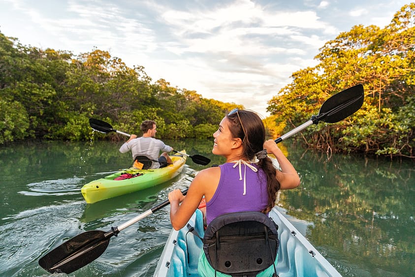 A man and woman kayak along a Florida river.