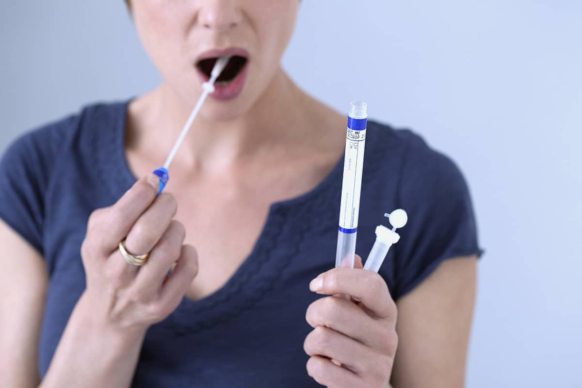 woman taking a tongue swab test showing the Benefits of Drug Testing