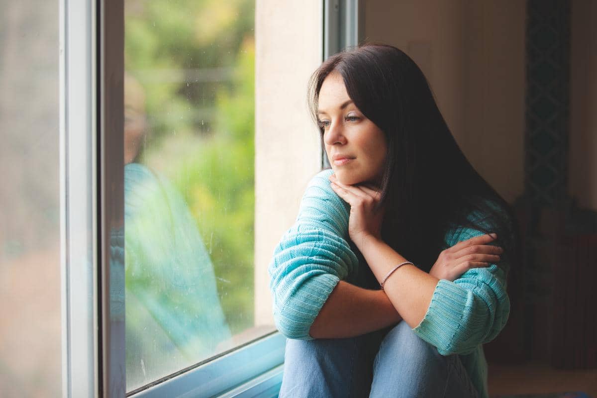 depressed woman looking out her window depressingly wondering the importance of healing from depression