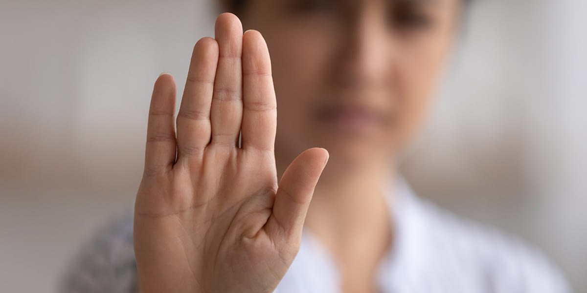Woman putting hand up using an opioid refusal strategy