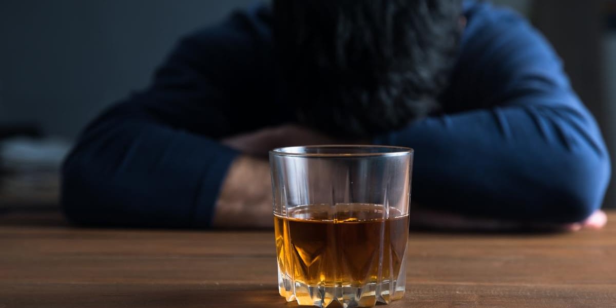 man with drink struggling with signs of alcohol dependence