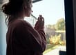 a woman looking out a window thinking about postpartum depression in new mothers