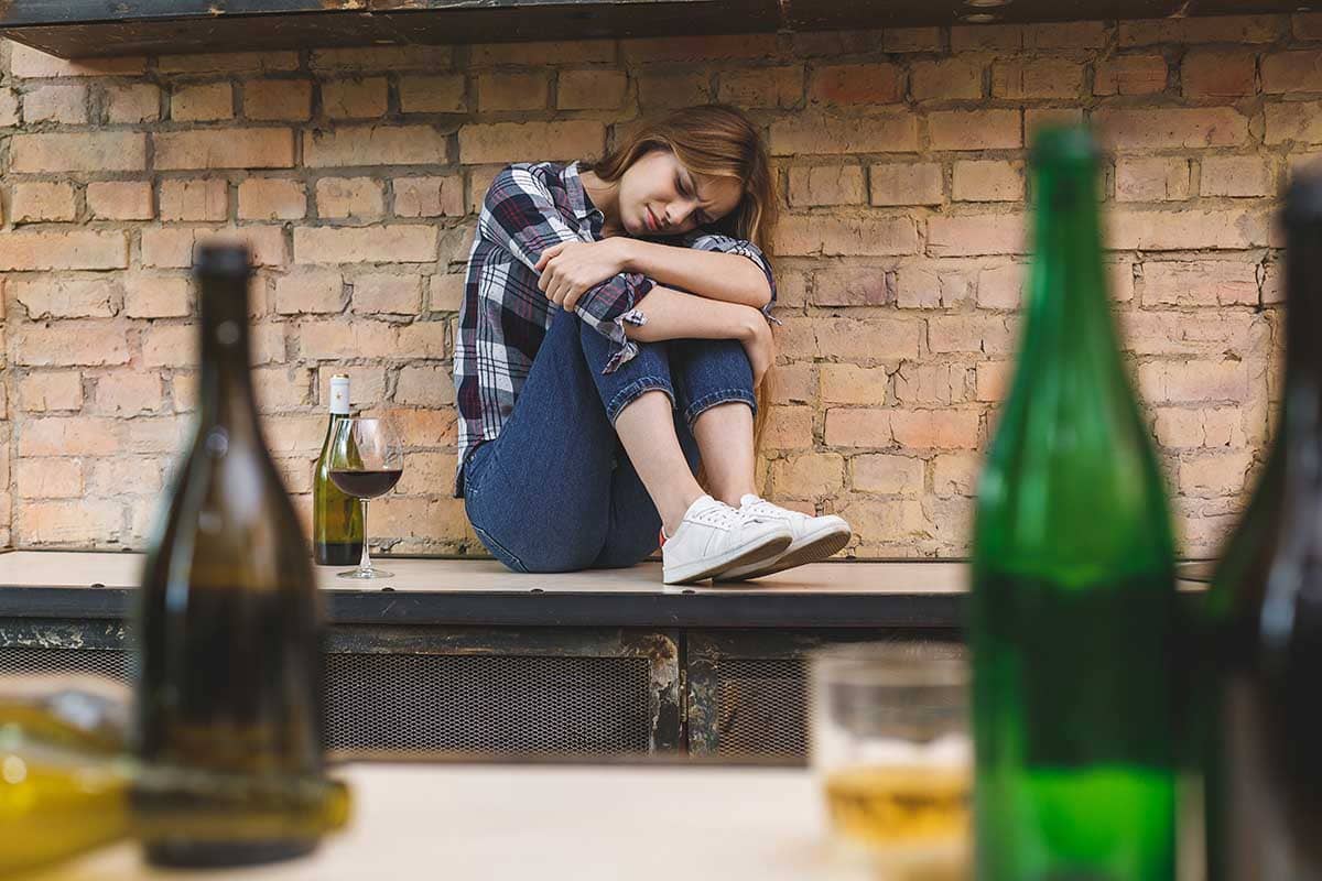 a woman feeling upset while thinking about alcoholism and anxiety