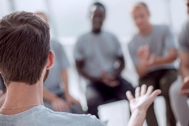 man talking in addiction support group for men