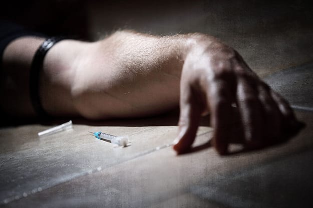 a man lying next to a needle thinks about the opiate overdose timeline