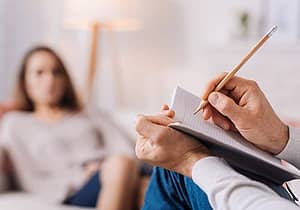a therapist writing down information about behavioral health services