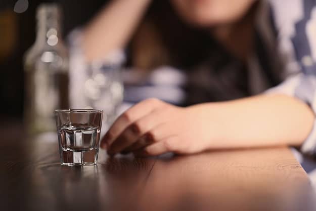 Person at bar thinking about binge drinking statistics