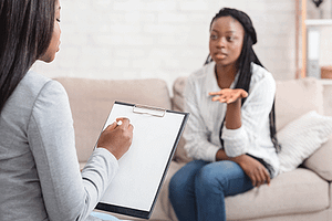 Woman sits on couch and talks to therapist about referring professionals resources