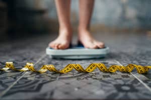 Woman steps on scale as she enters eating disorder treatment