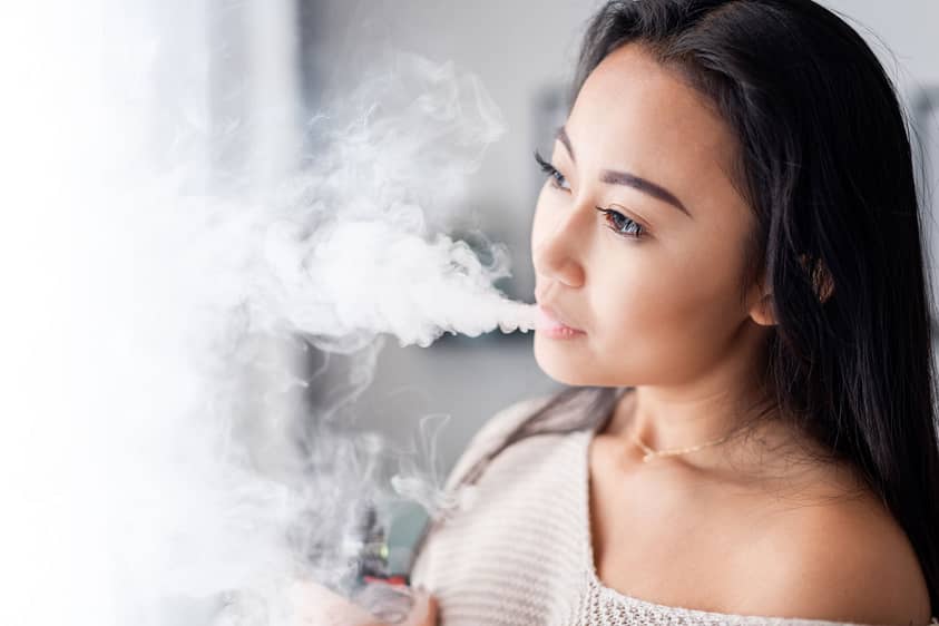 Woman exhales marijuana as she ponders marijuana withdrawal symptoms