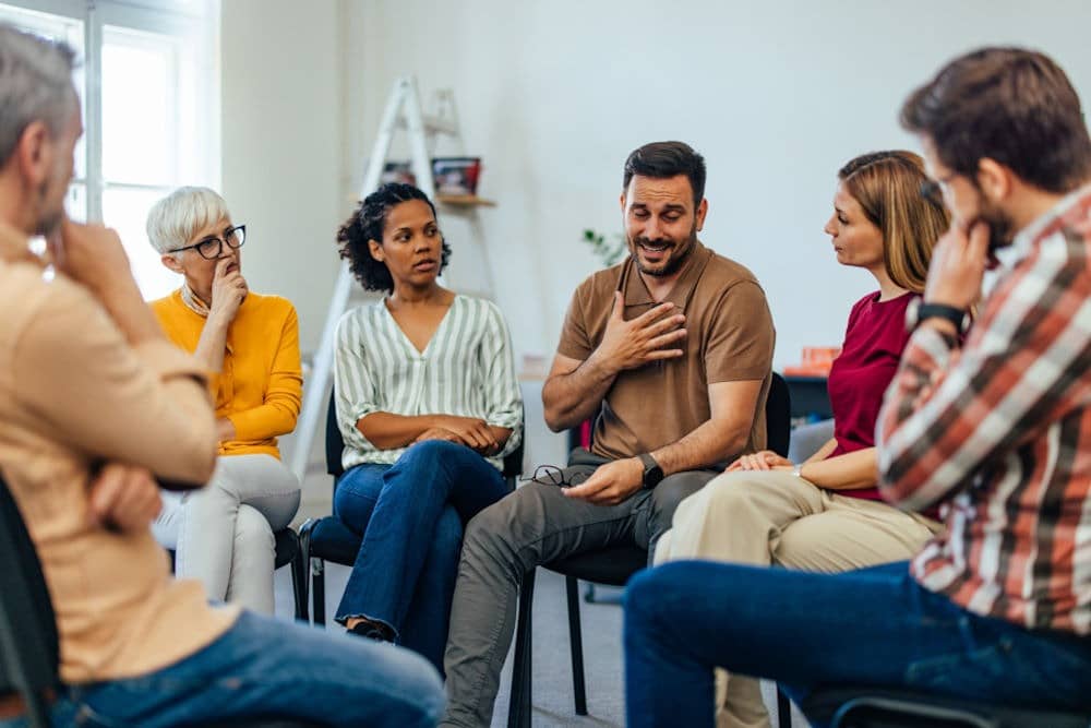 man getting emotional in group therapy