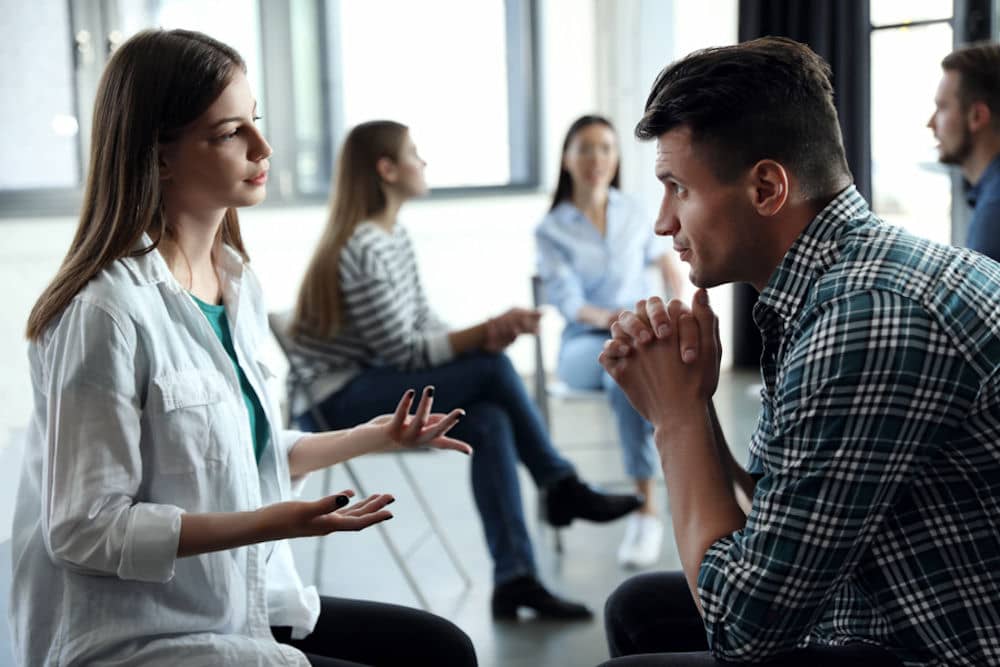 man and woman having a discussion about boundaries in group meeting