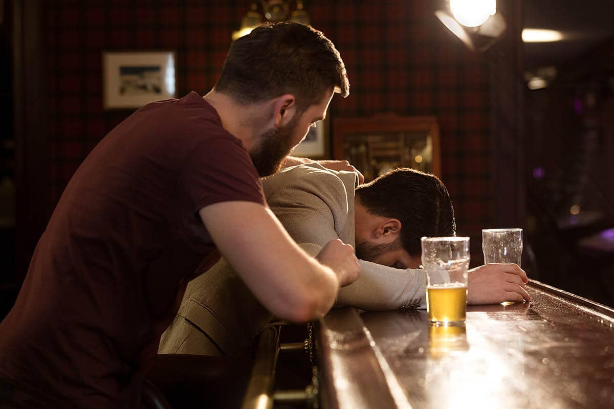 man wonders how to help an alcoholic while he tries comforting his friend