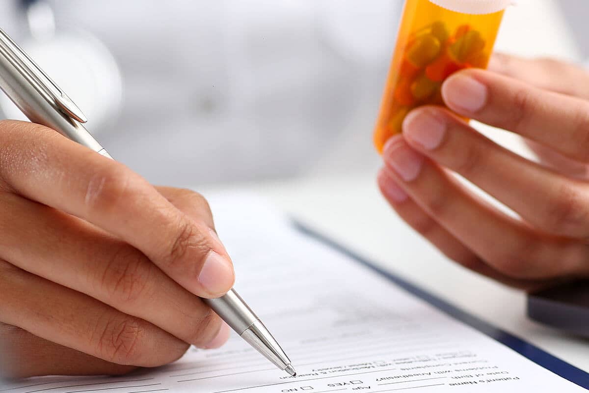 a doctor writes a prescription and thinks about the drug facts you should know