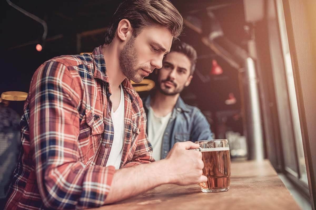 man sitting with friend getting help for an alcohol addiction