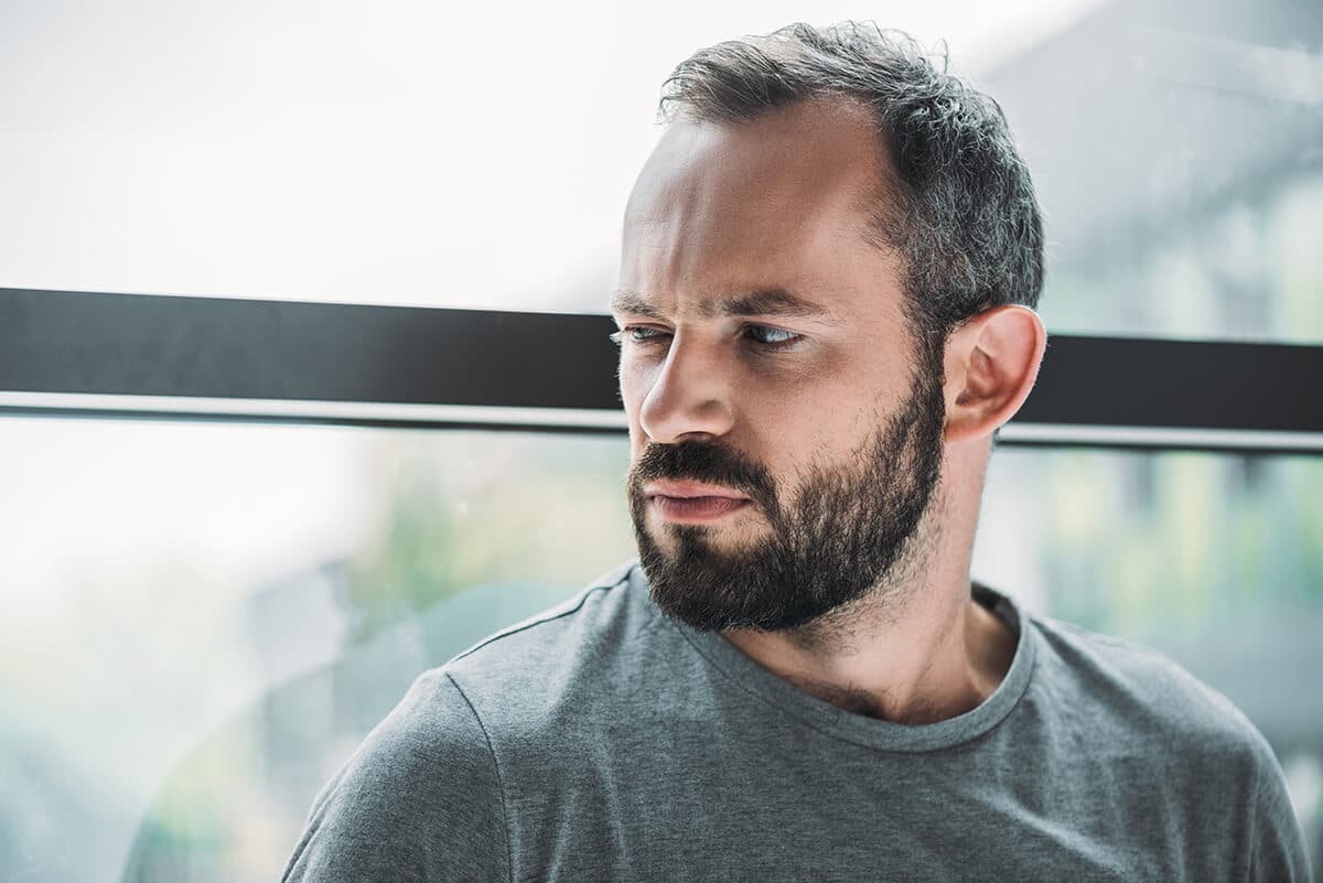 man sitting next to window and thinking on national drug takeback day
