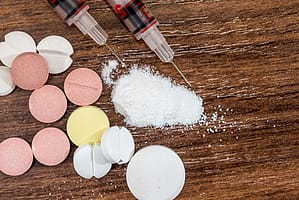 pills, powder, and needles on table - detox definition
