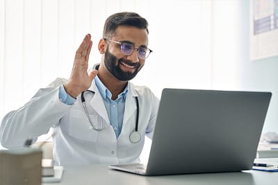 doctor greeting his telehealth patient over video chat