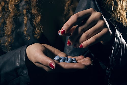woman popping pills wonders about opiate detox timeline
