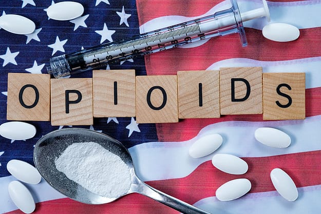 opioid epidemic paraphernalia lies on top of an American flag