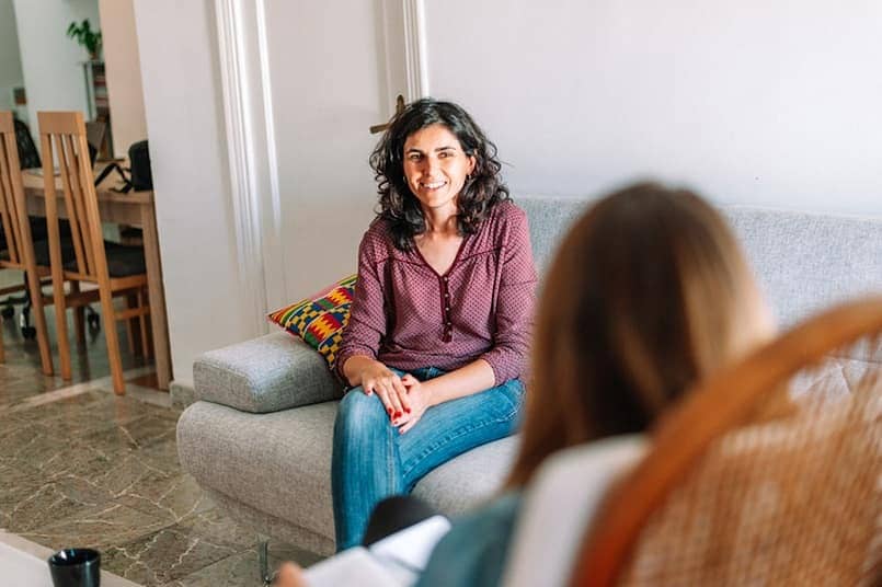 smiling woman sitting in therapy