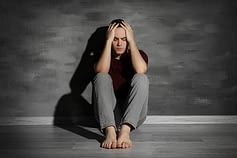 Depressed guy against wall may benefit from addiction rehab