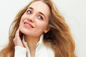 what is drug detox - woman with long hair and white sweater touching her neck