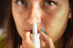 Woman with nasal spray in her nose knows what is NARCAN