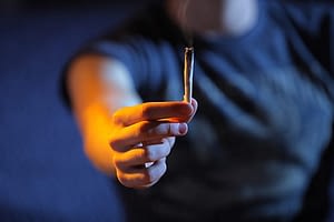 Person holding out an enticing joint but is marijuana addictive?