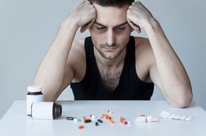 Despairing man in front of pills needs to detox from percocet