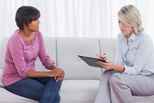 Two women, one a therapist conduct individual therapy.