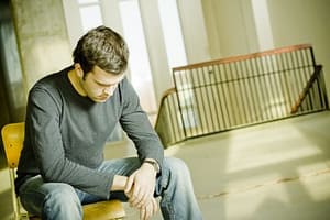 New York drug detox centers - man looking down sitting on steps