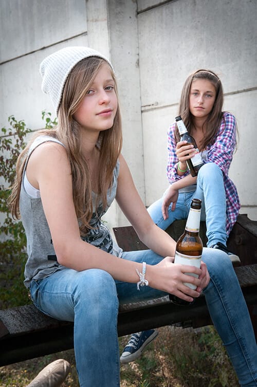 two girls sitting on step exhibit Teen Alcohol Abuse while drinking beer
