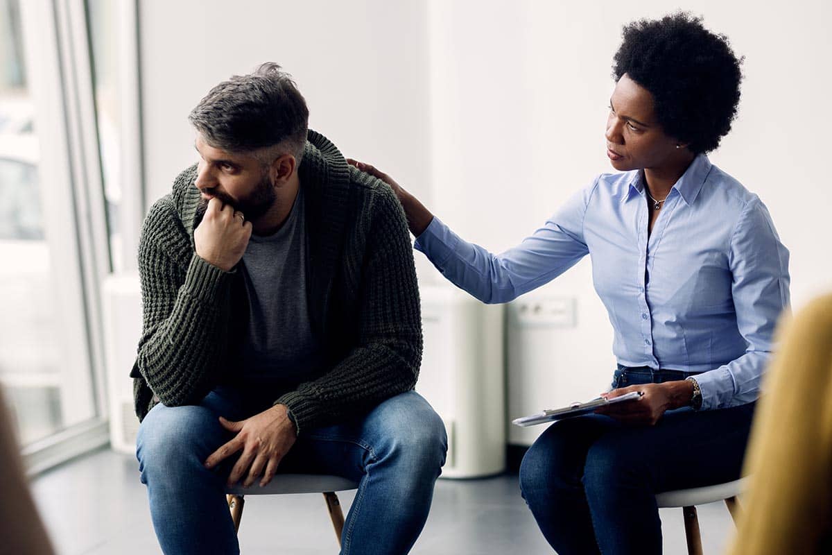 woman comforting man in support groups for addiction recovery