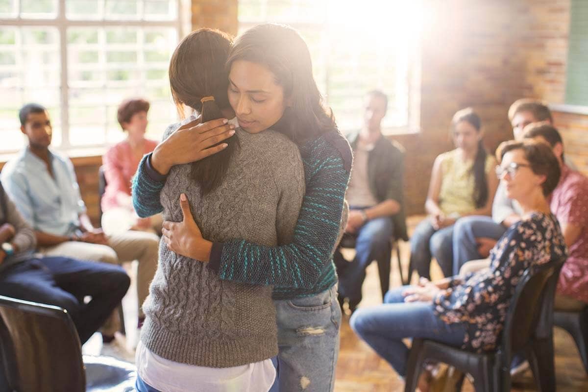 two people hugging while learning about types of alcohol treatment programs