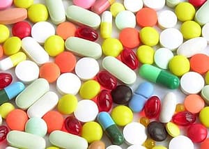 A table covered in many colors of pills represents many different types of amphetamines