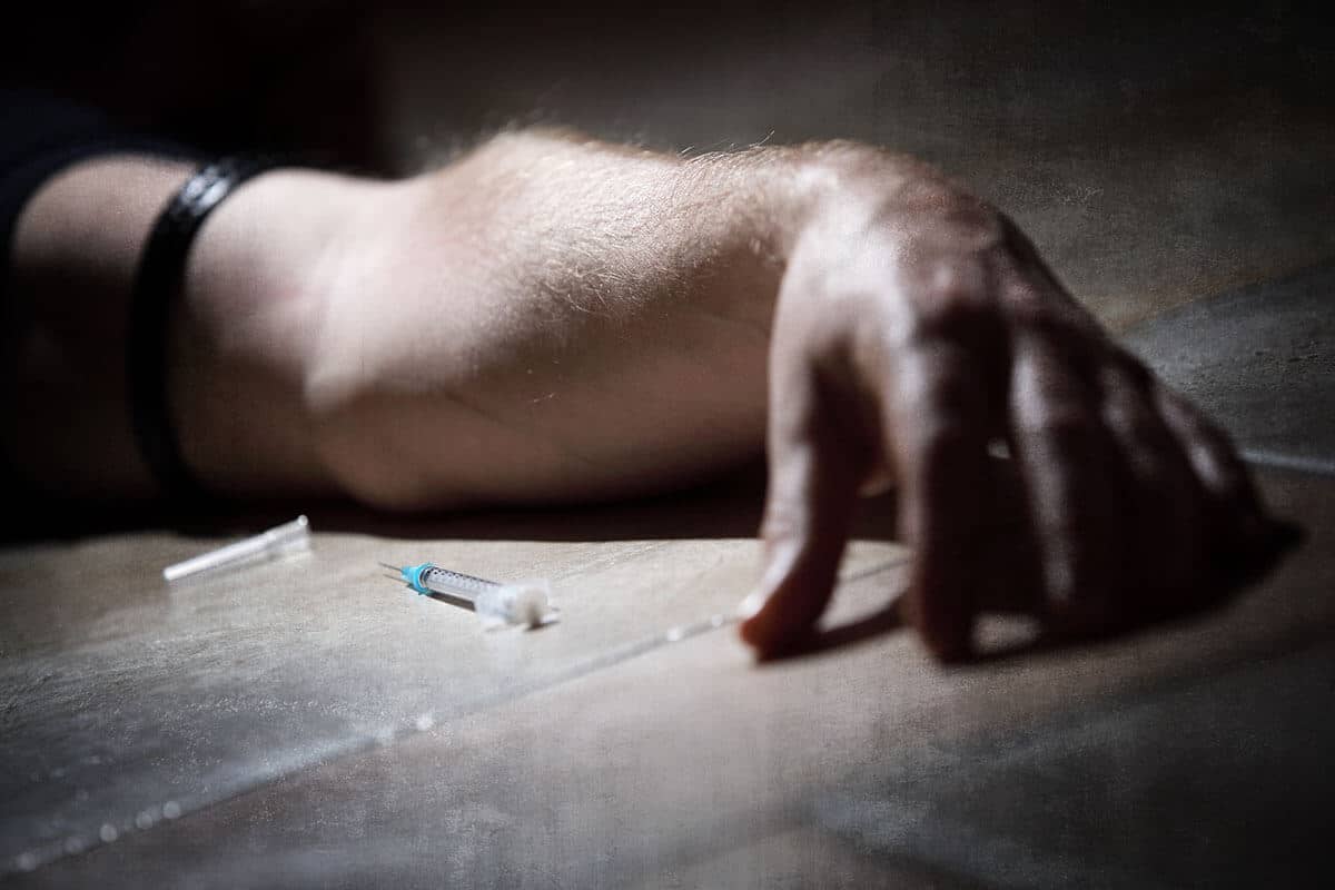 a man lying next to a needle thinks about the opiate overdose timeline