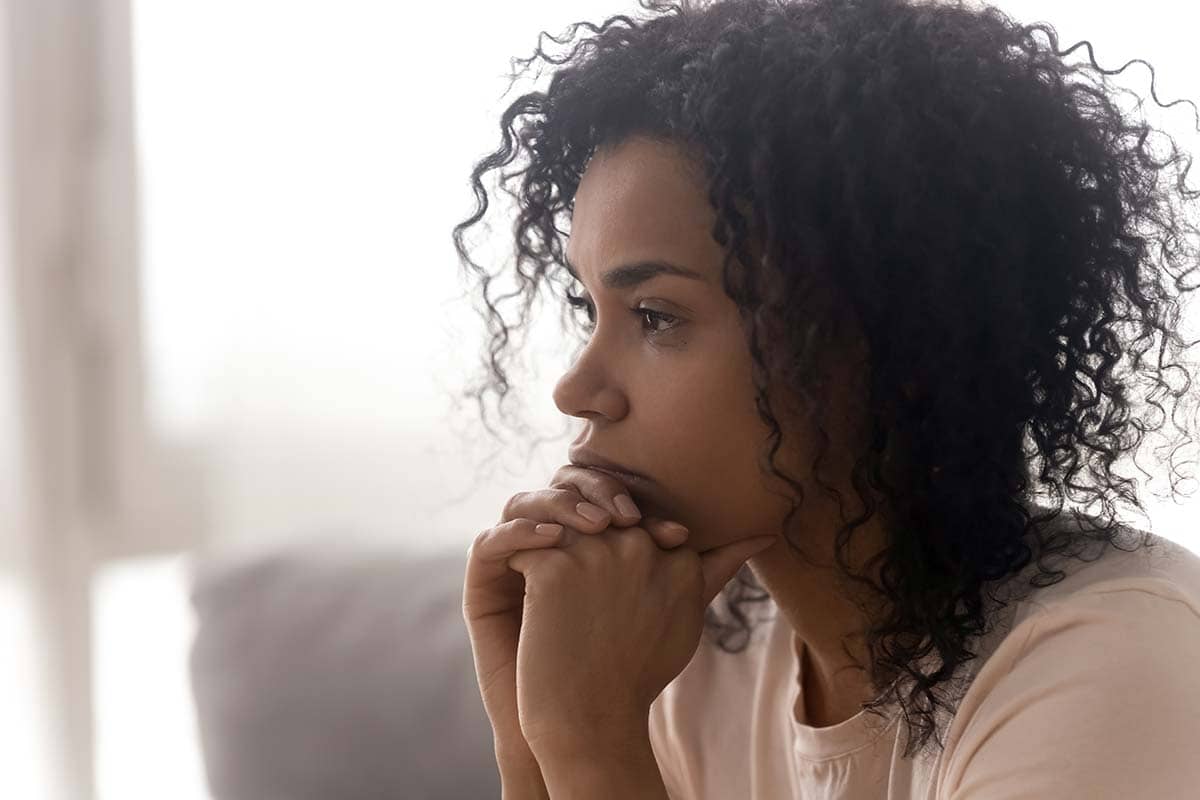 woman sitting on couch thinking about what is chemical dependency before taking medication