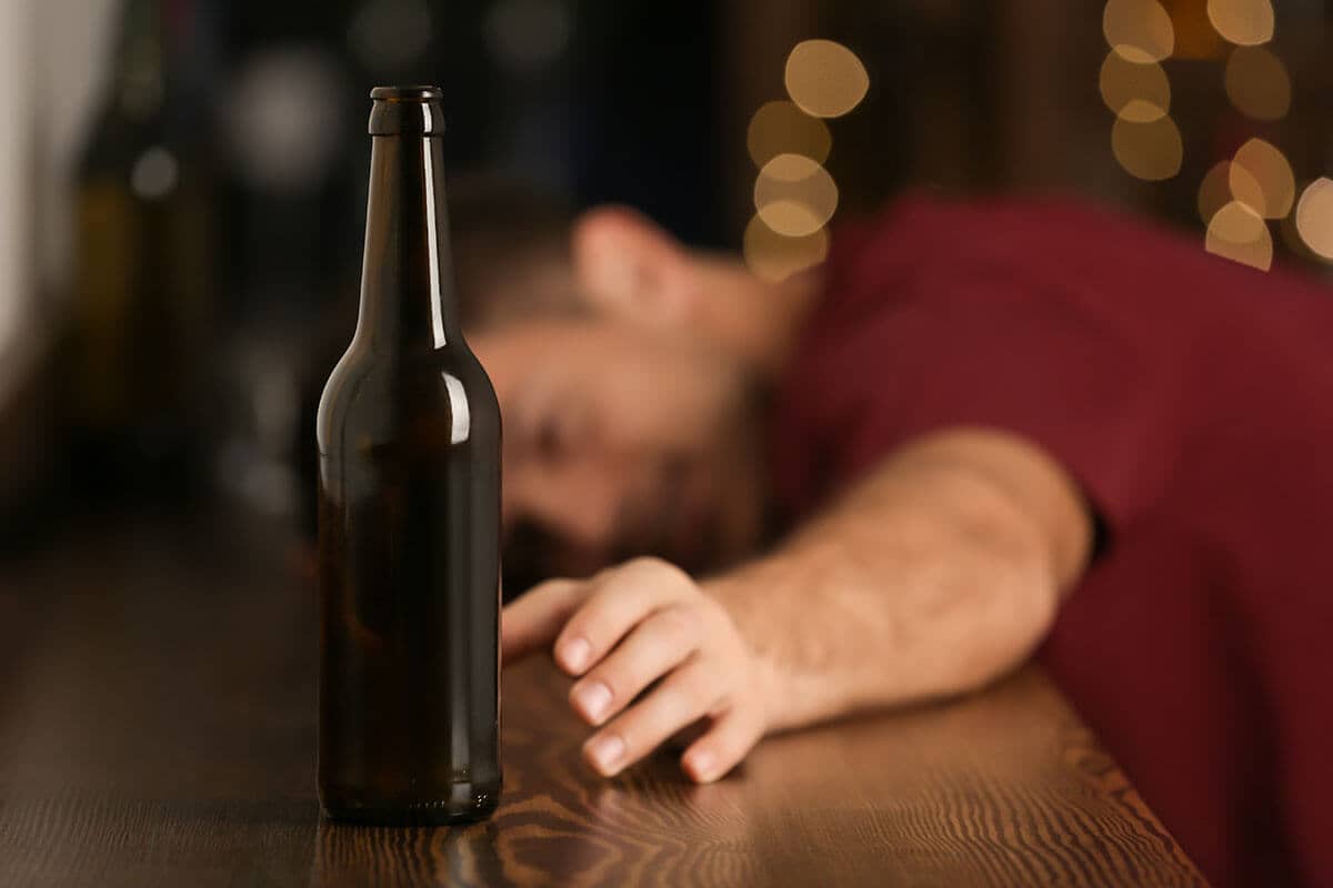 man suffering from the dangers of binge drinking