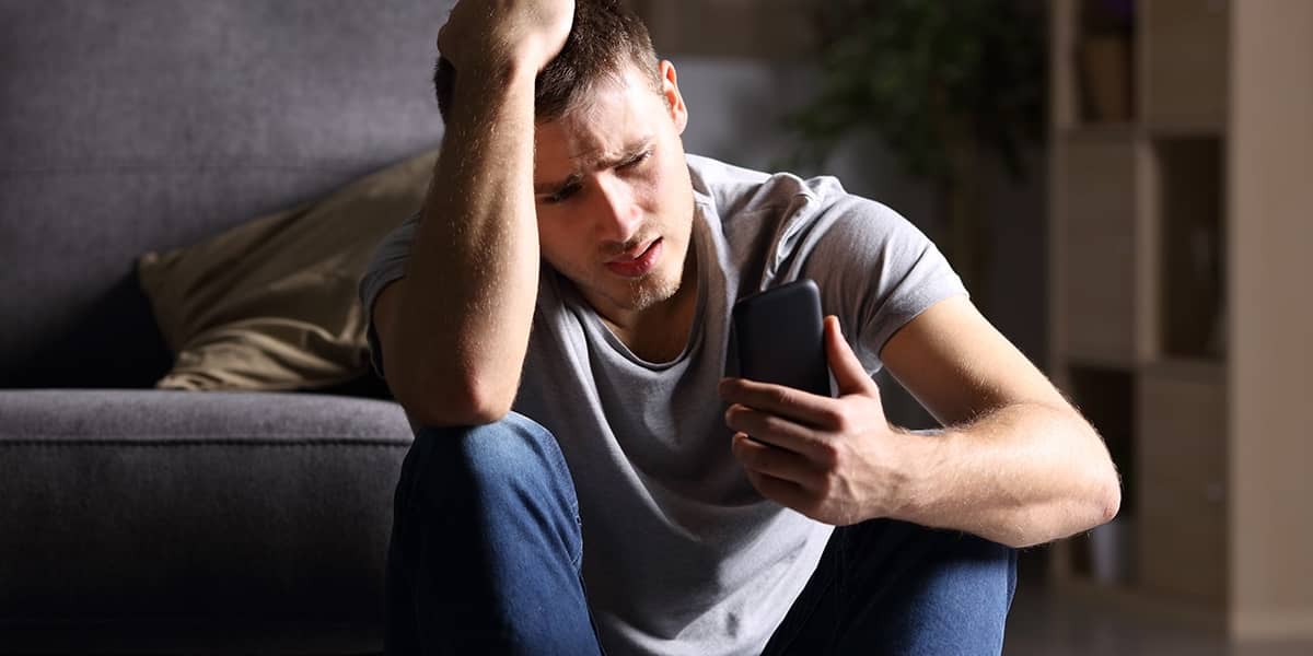 Man holding phone knows he needs addiction help for men