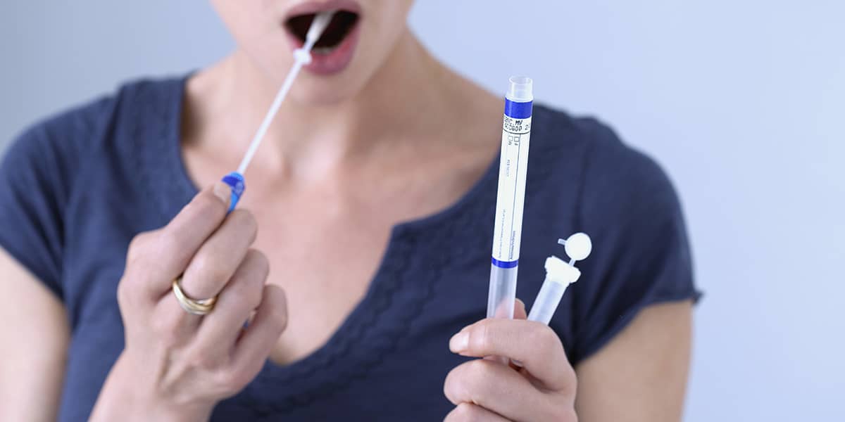 woman taking a tongue swab test showing the Benefits of Drug Testing
