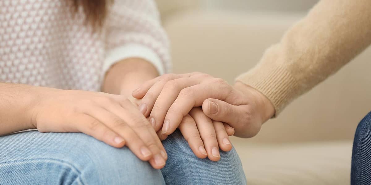 two people holding hands talking about preventing suicide