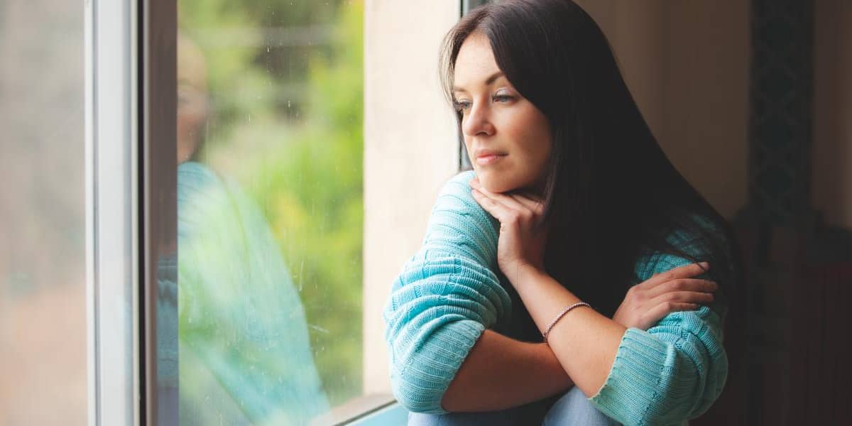 depressed woman looking out her window depressingly wondering the importance of healing from depression