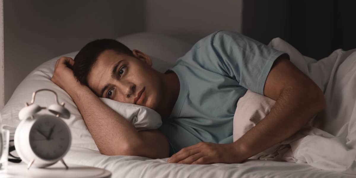 man laying in bed because showing signs of benzo addiction