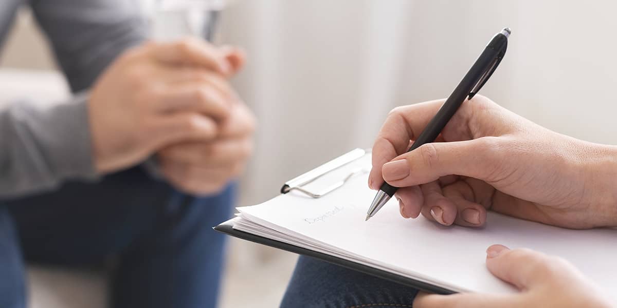 therapist taking notes on drug abuse habits of patient