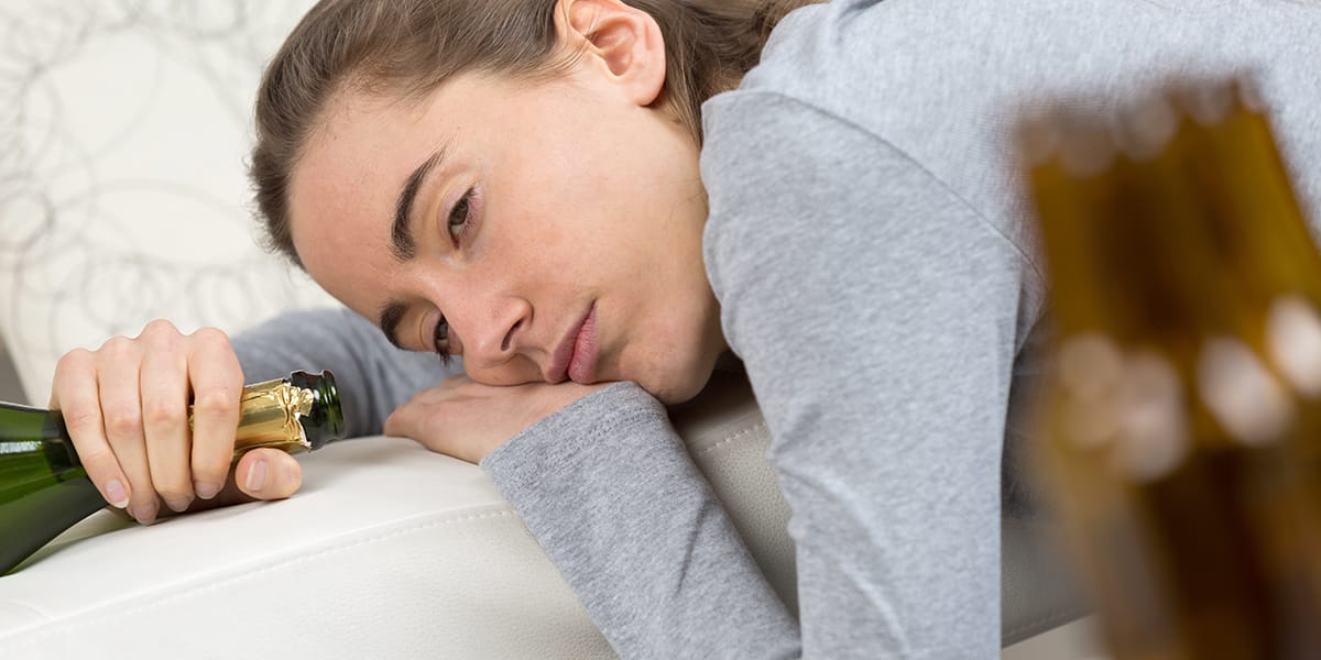 young woman passed out on couch making spouse wonder how to live with an alcoholic